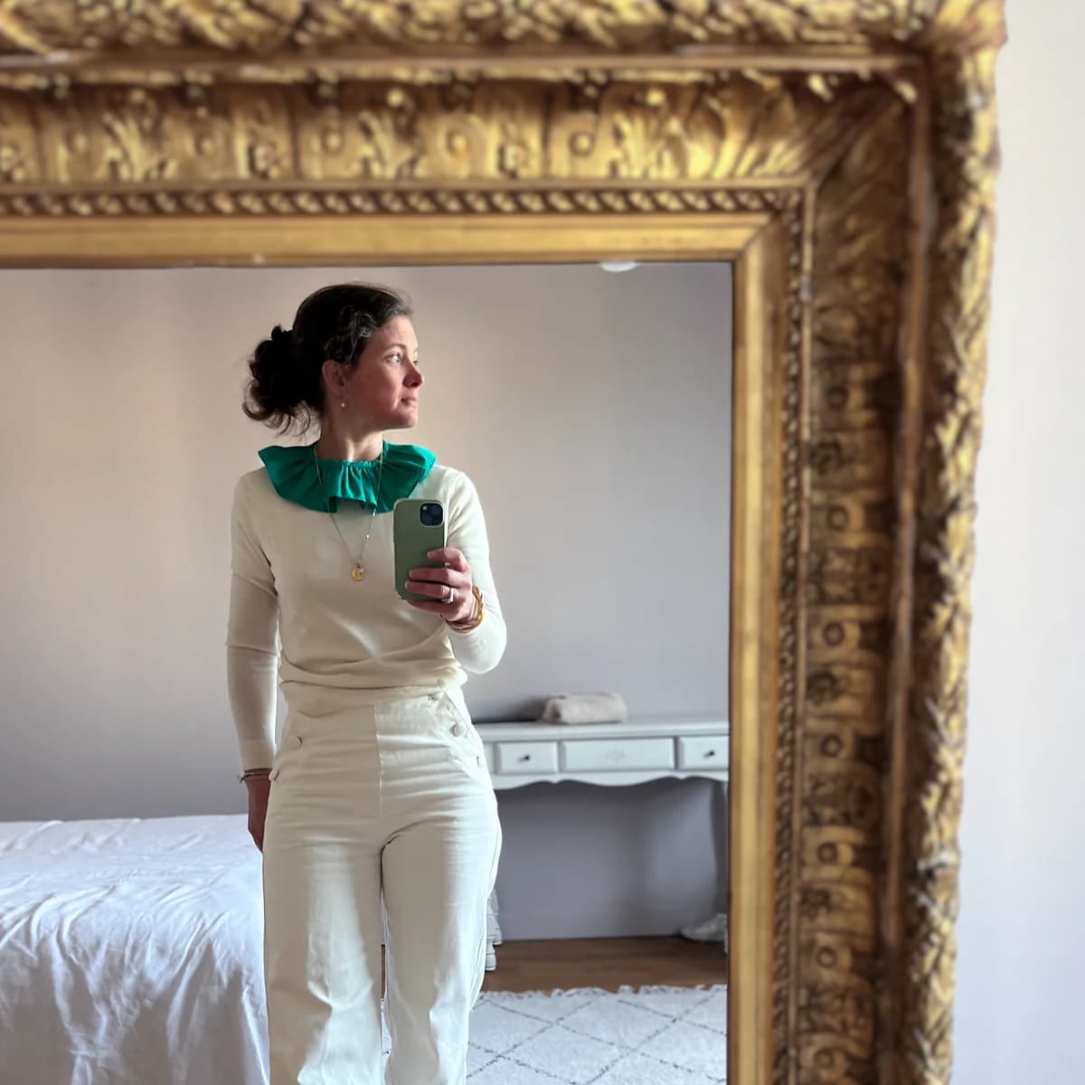 Stéphanie selfie dans un miroir doré, col claudine vert émeraude bouffant sur pull ivoire, tenue monochrome crème — By Mésange