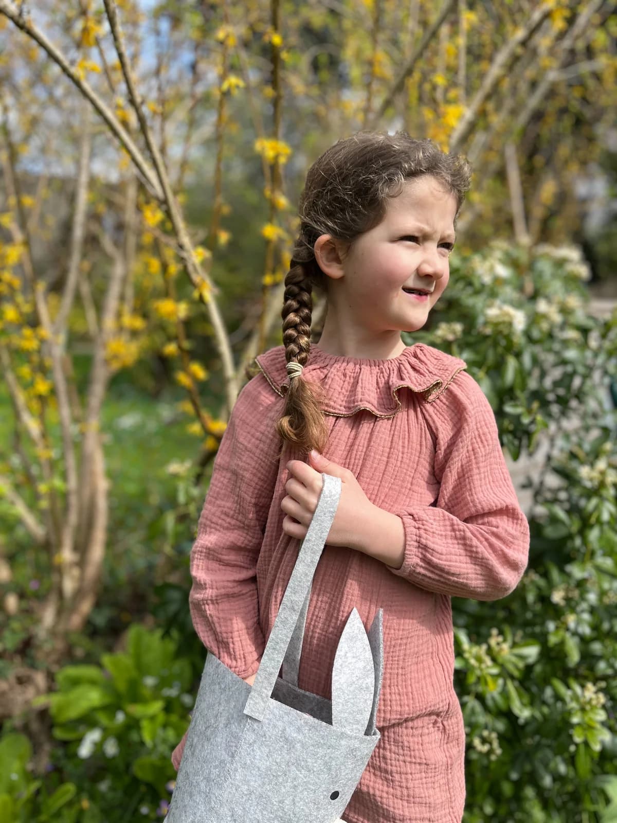 Blouse rose gaze, sac lapin Petite fille au jardin en blouse rose gaze de coton volantée, tenant un sac lapin en feutrine