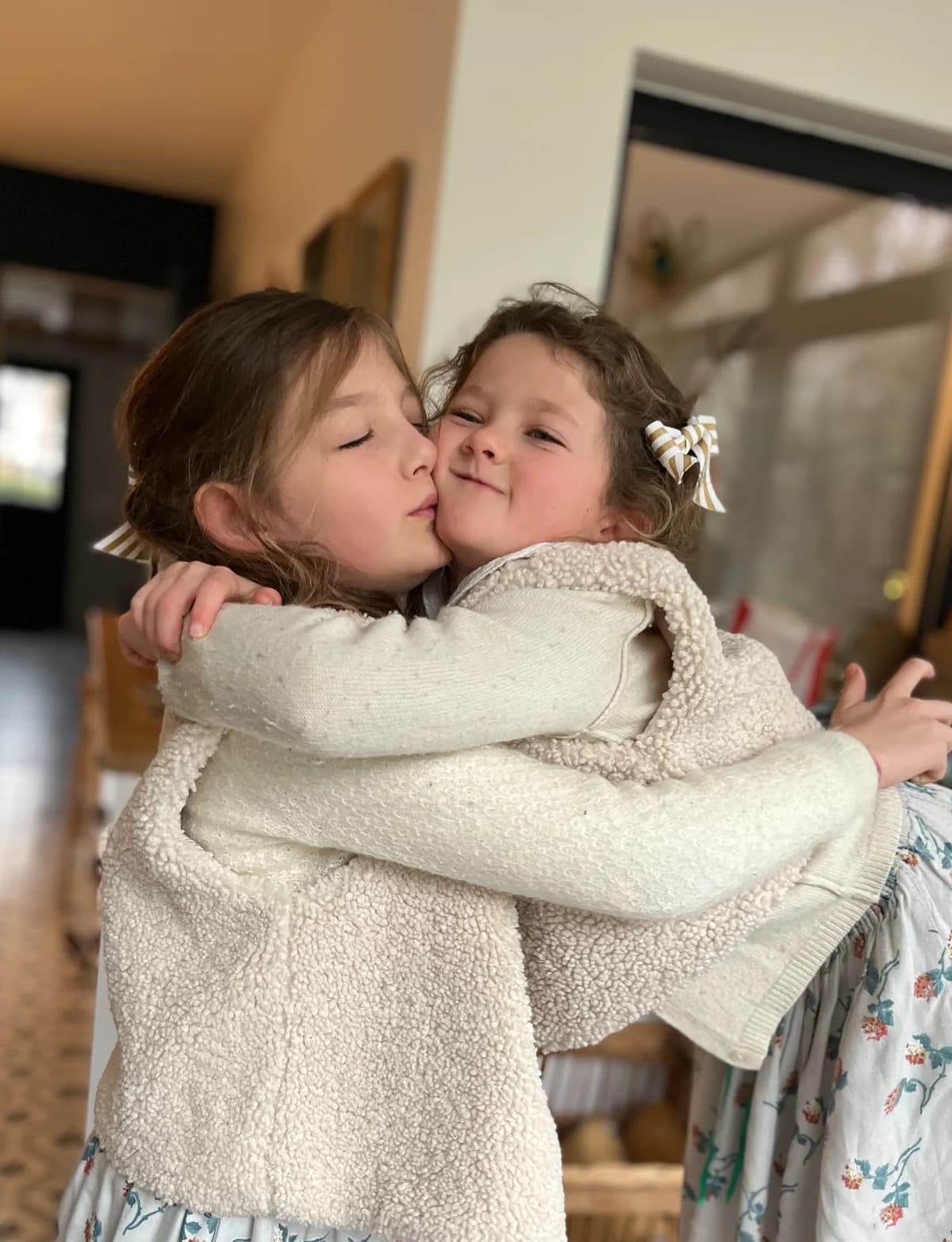 Deux sœurs, gilets berger Deux sœurs s'embrassant en gilets berger ivoire — vêtements enfant By Mésange