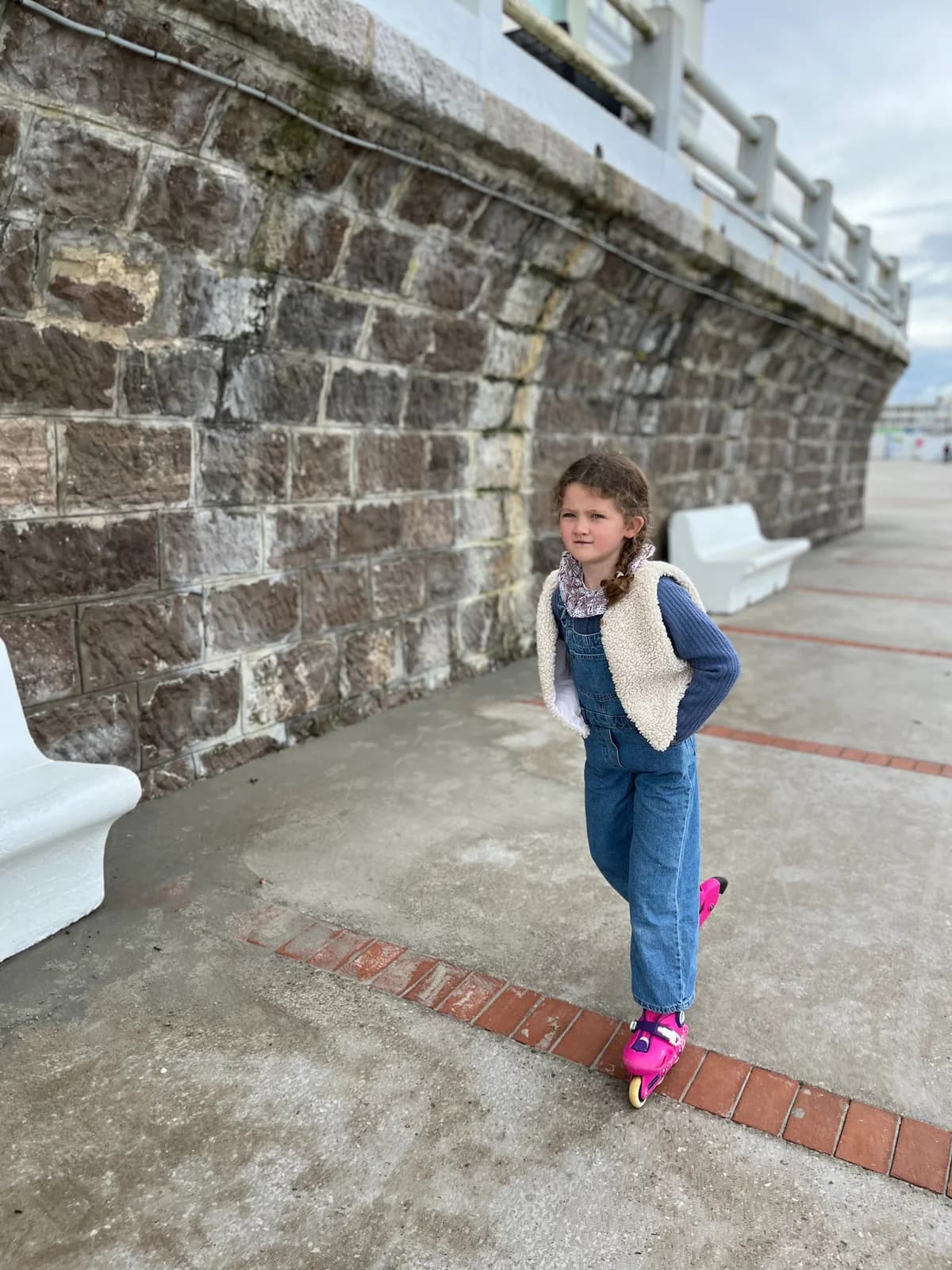 Fillette en patins, gilet berger Fillette en patins à roulettes — salopette en jean et gilet berger blanc, bord de mer — By Mésange