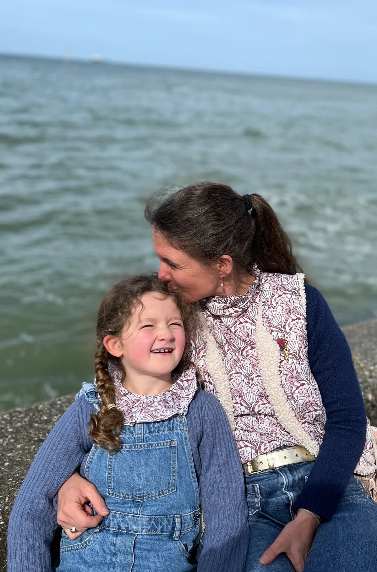 Mère et fille, bord de mer Stéphanie et sa fille assises au bord de mer, blouse paon et salopette en jean — By Mésange
