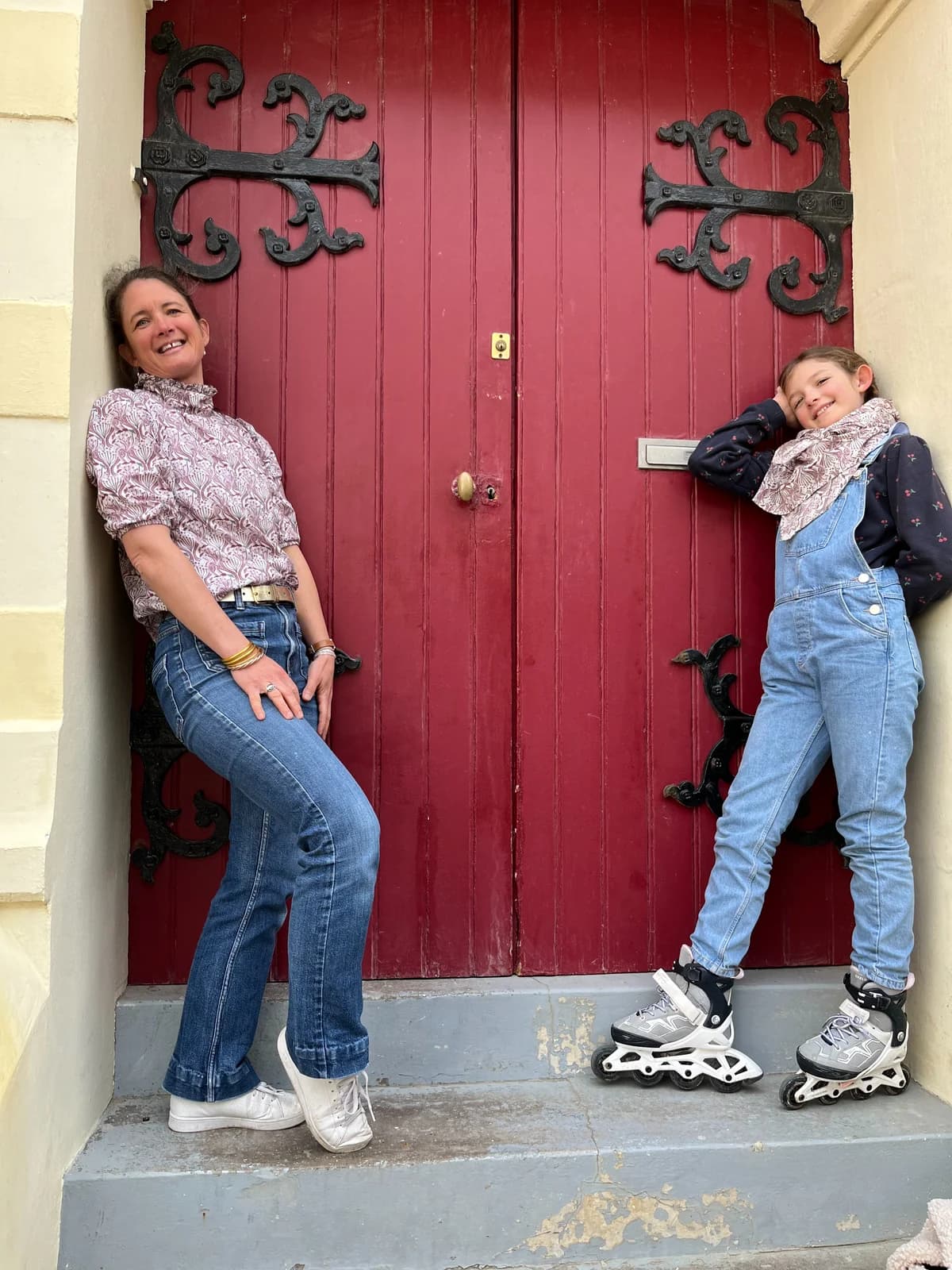 Porte rouge, blouse paon Mère et fille devant une porte rouge, blouse paon et salopette en jean avec patins — By Mésange