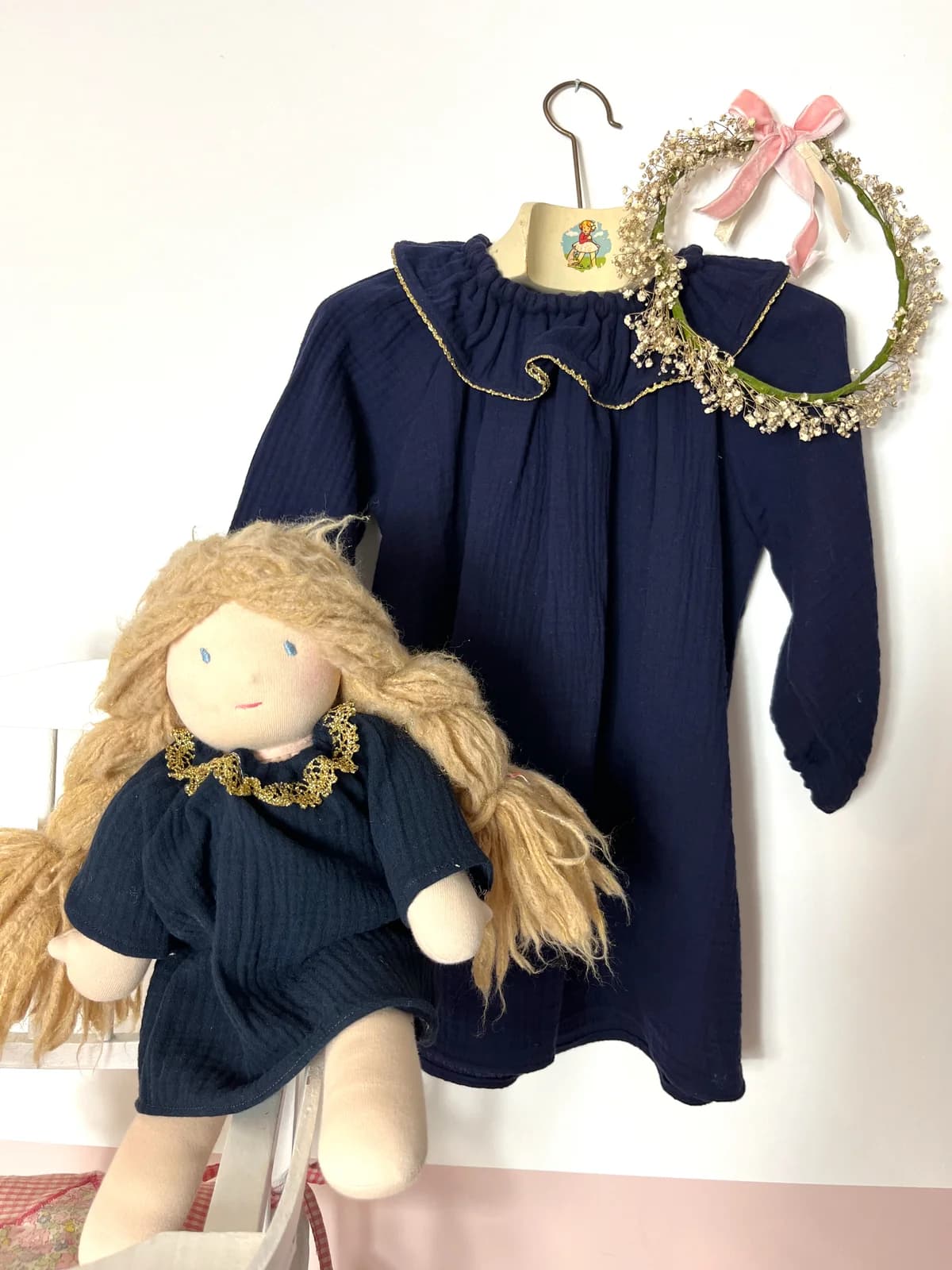 Robe gaze bleu marine enfant Robe enfant en gaze de coton bleu marine avec col doré, sur cintre avec couronne de fleurs séchées
