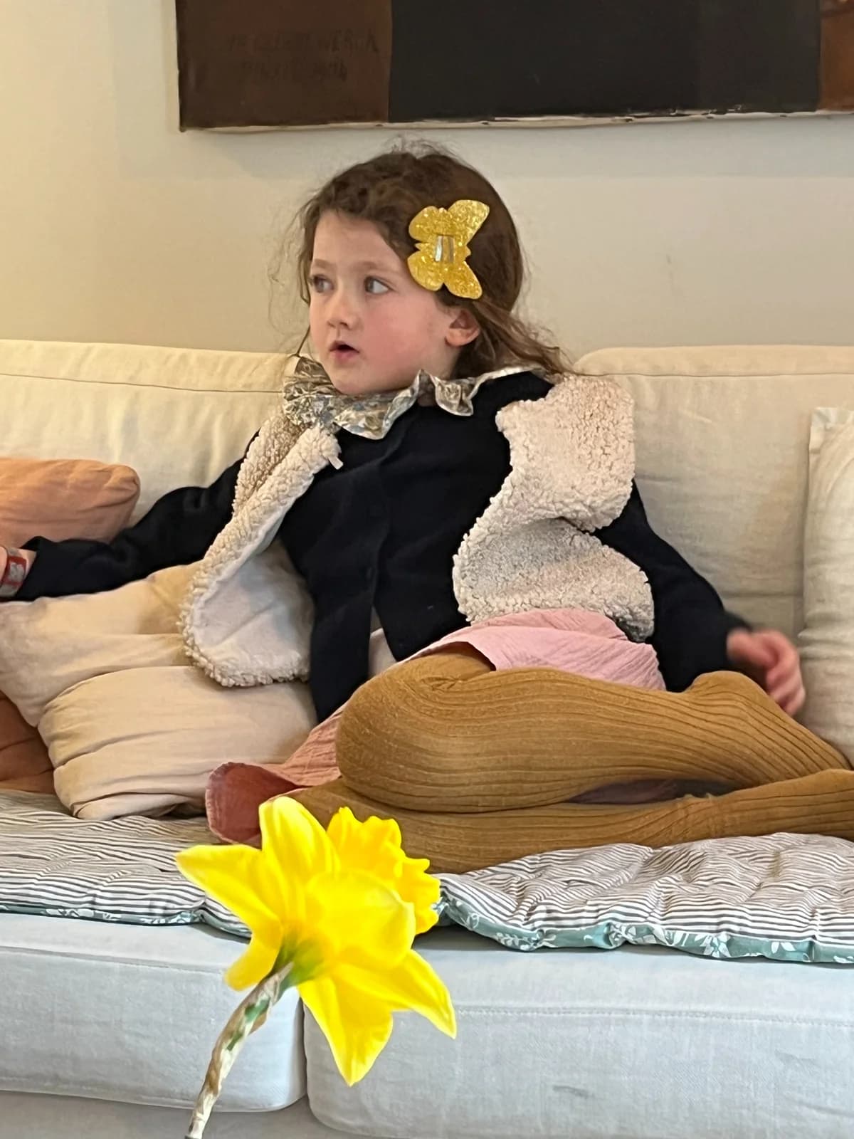 Robe noire, gilet berger Petite fille sur le canapé en robe noire et gilet berger, barrette papillon dorée — By Mésange